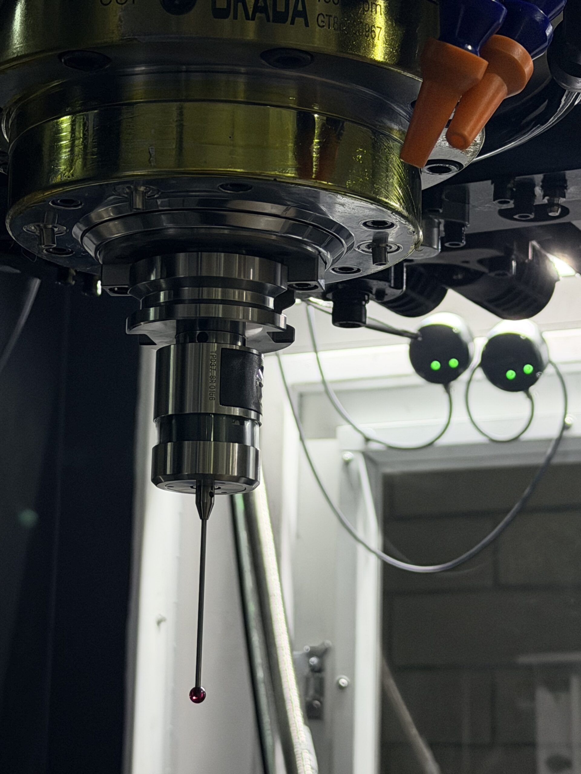 Workpiece probe locating a bore beside a tool setter measuring an end mill
